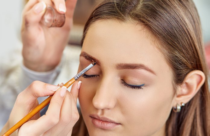 Beautiful young girl dyed her eyebrows in a beauty salon