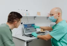 Czy można rozłożyć leczenie stomatologiczne na raty bez dodatkowych kosztów Dentysta omawia z pacjentem plan leczenia z wykorzystaniem laptopa.